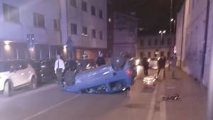 Perde il controllo dell’auto che finisce contro altre due macchine in sosta e si ribalta