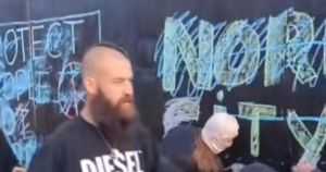 Flag protester branded woman paedophile in clash over defaced asylum-seeker mural
