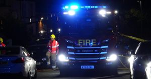 Flames rip through city building as blue lights fill street