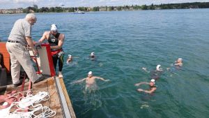 Elf Schwimmer wollen eine 150 Tonnen schwere Fähre in die Mitte des Bodensees ziehen