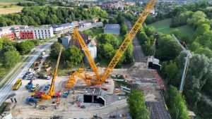 Schwebende Giganten und ein Riesenkran: Eine ganze Bahnüberführung hängt in der Luft