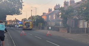 Road closed as fire sends smoke billowing from behind homes