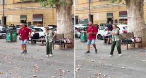 An old man and woman dance to pop music in a Roman piazza, not a tip jar in sight
