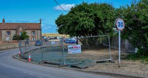 Village green fenced off after parking row at harbour