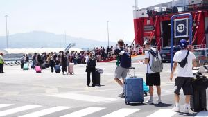 Nel porto assaltato dai vacanzieri, si salva la vita a un immigrato