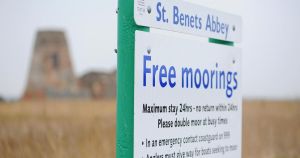 Boat sinks at moorings by medieval monastery on Broads