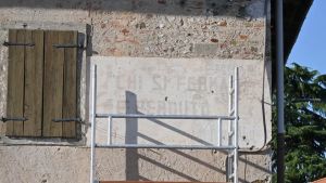 C’è chi vuole restaurarle e chi cancellarle, i lavori sulle scritte attribuite a Mussolini accendono il dibattito nella Bassa