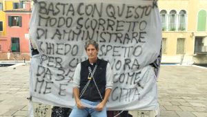 Venezia, ambulante si incatena al banco: «Il Comune non penalizzi chi lavora da una vita»