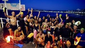 Los bañistas de la rampla de Gijón despiden el verano con su travesía nocturna: 