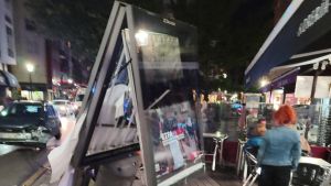 Espectacular accidente en Gijón por un coche que se estampó contra un mupi: “Casi se lleva toda la terraza”