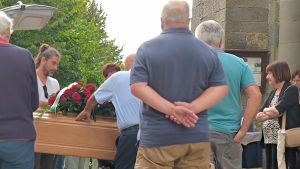 Il funerale di Giancarlo, morto per una misteriosa ferita alla gamba. In chiesa il silenzio della moglie, indagata per omicidio