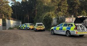 Police cordon off section of industrial estate with dog unit at scene